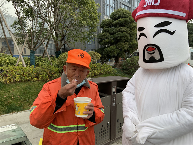 粥大白將臘八粥送至環衛工人們的手中
